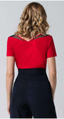 Woman wearing a red office elegant blouse Lola Top with pleated neckline detail, paired with high-waisted black trousers, back view.
