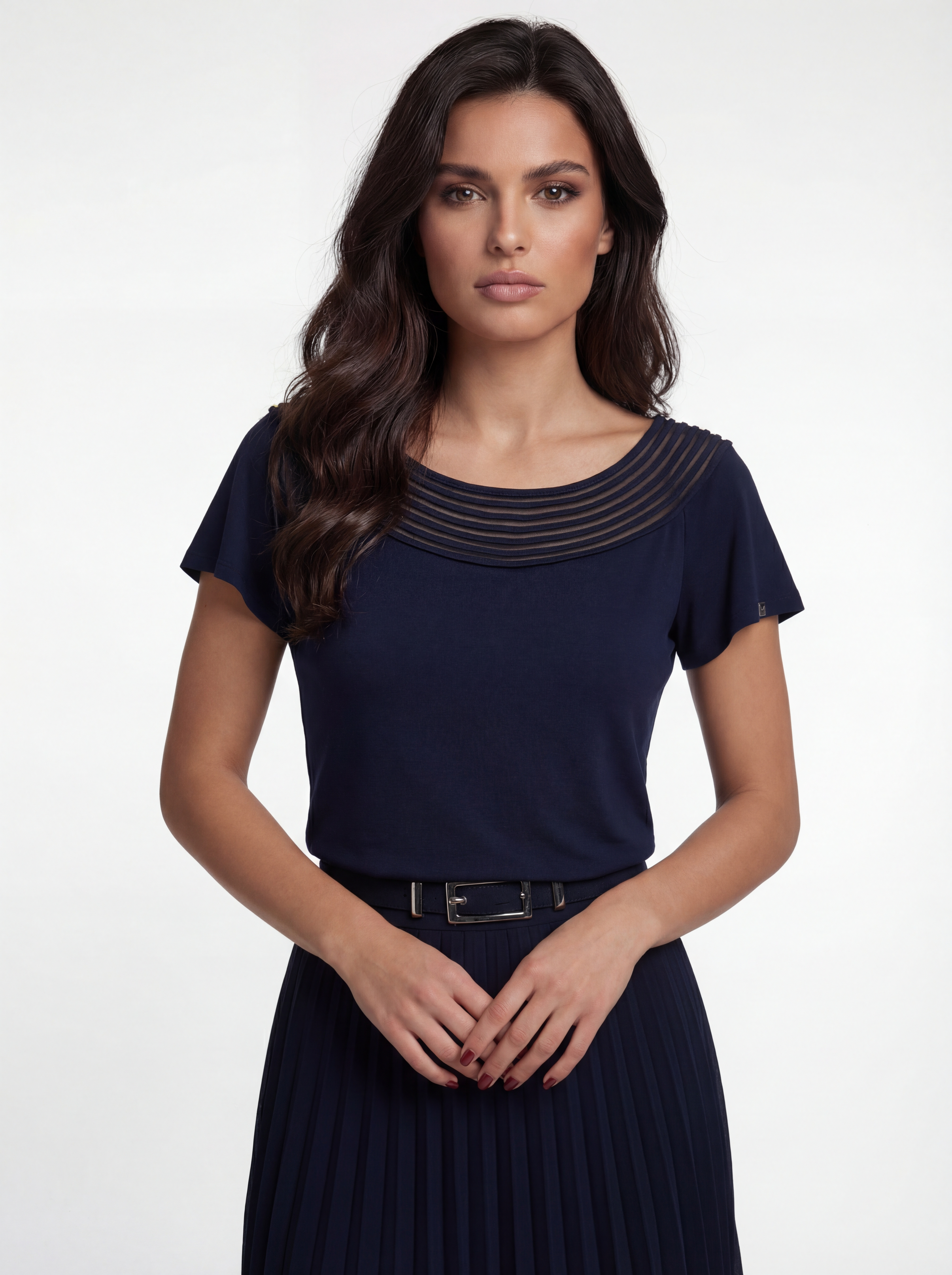 Woman wearing a navy blue dress with a belt on a white background
