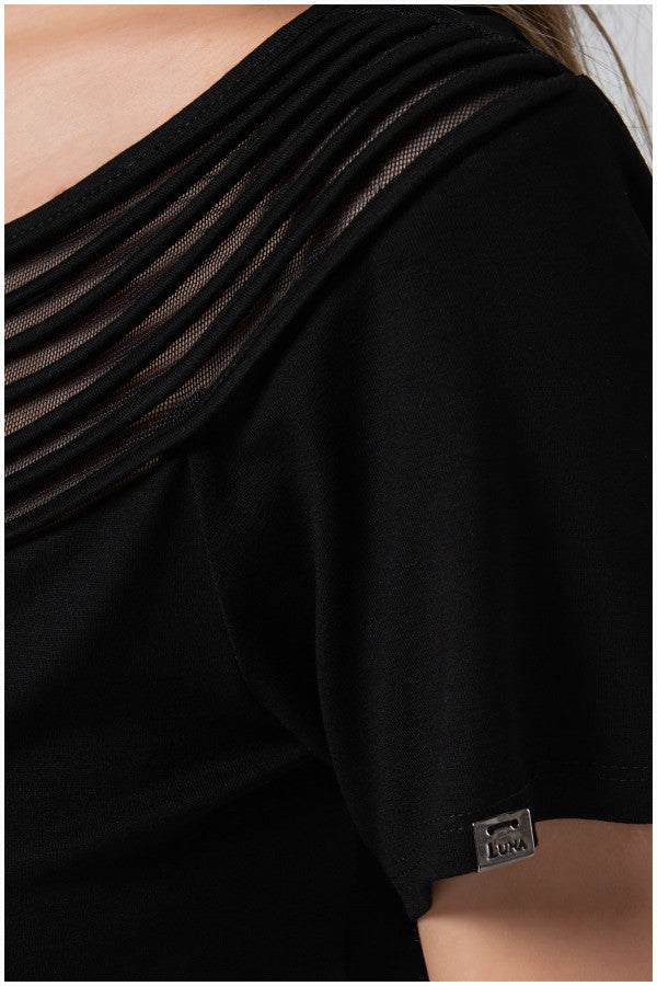Close-up of black Lola business Top featuring a pleated neckline and short sleeve with a small brand tag.