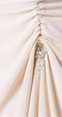 Side-gathered ruching at the right hip with hanging crystal cluster drop on pale beige polyester crepe