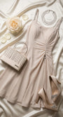 Lesli Short Dress styled on ivory satin with crystal handbag, crystal necklace, beige pumps, and cream rose