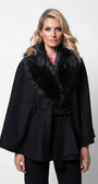 Woman wearing a black coat with a fur collar against a white background
