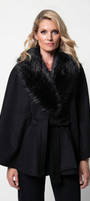 Woman wearing a black coat with a fur collar against a white background