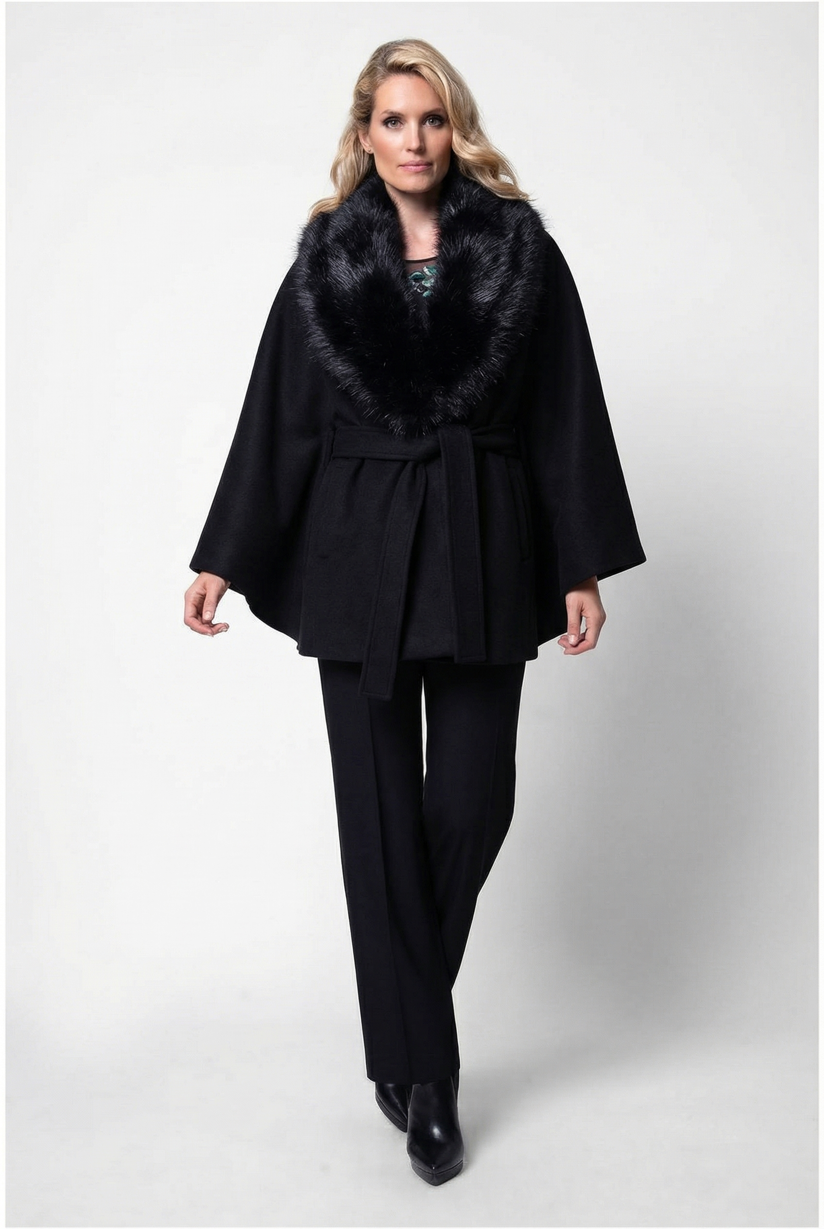 Woman wearing a black outfit with a fur collar on a white background