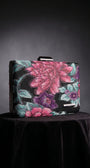Regina floral clutch front view highlighting the vivid floral pattern, structured shape, and hardware.