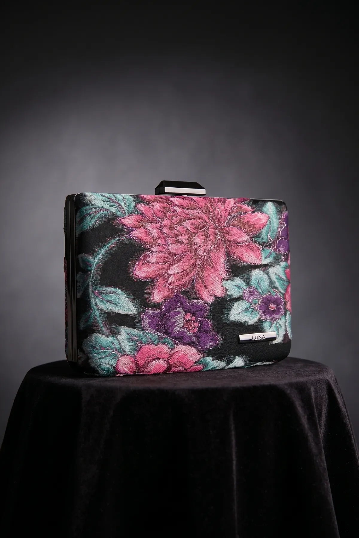 Regina floral clutch front view highlighting the vivid floral pattern, structured shape, and hardware.