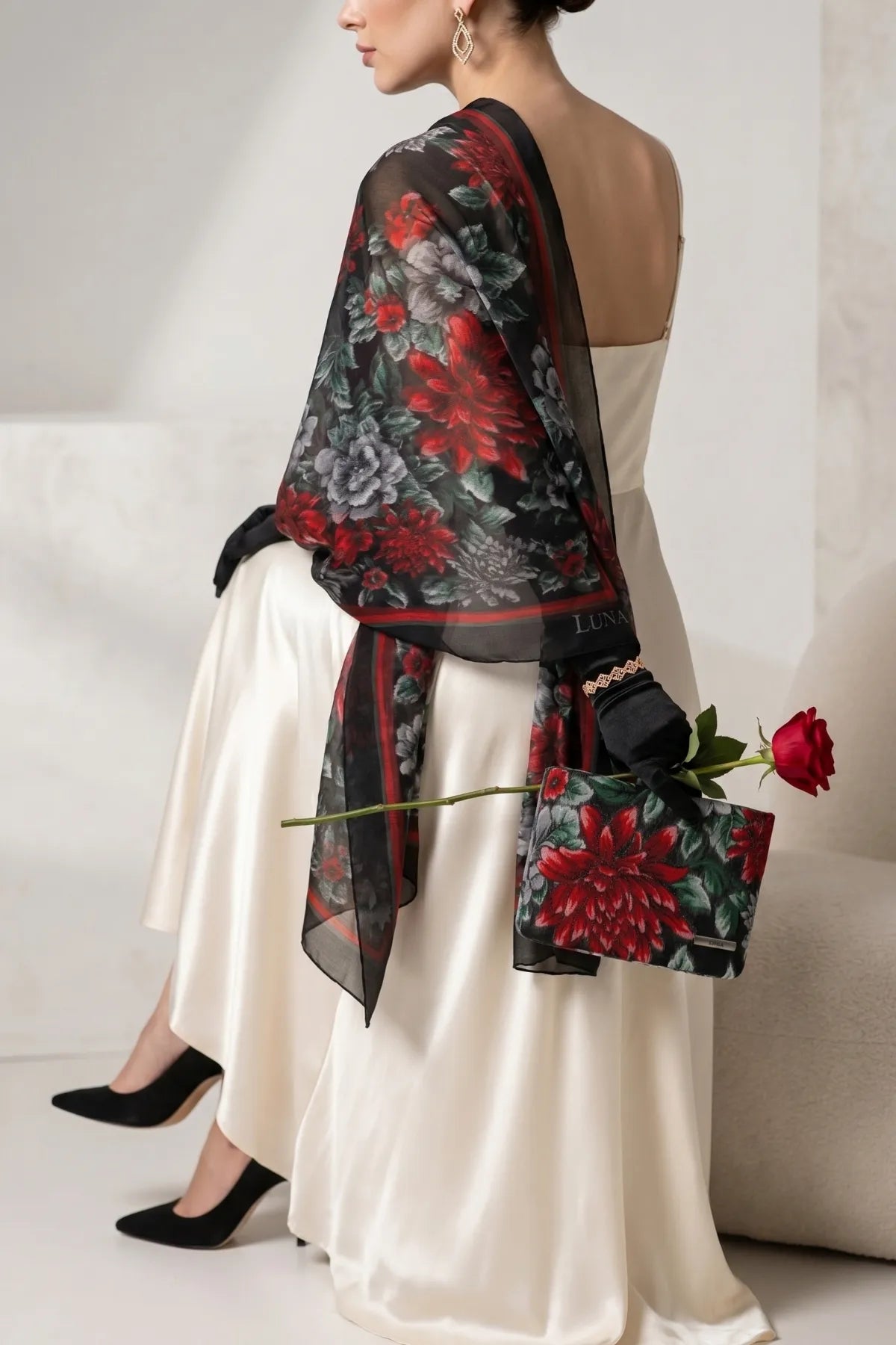 Regina floral clutch styled with an ivory dress, sheer black floral scarf, heels, and a red rose.