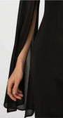 Detail of the Rebeka sheer chiffon cape sleeve, open along the arm over the black sheath