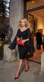 Rebeka black dress styled on satin with red heels, red clutch, ruby jewelry and a red rose