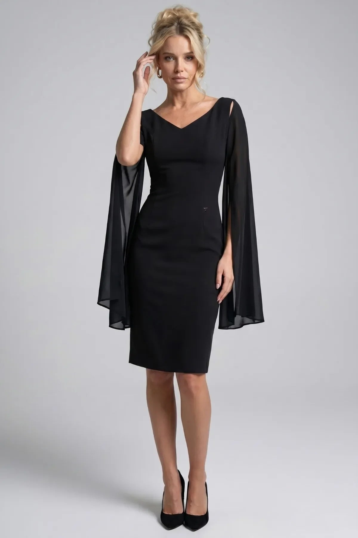 Front view of the Rebeka black fitted short dress with V neckline and flowing sheer cape sleeves