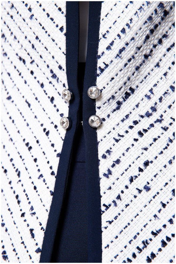 Close up of navy trim and crystal front buttons on white tweed blazer