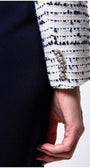Close up of navy trim and crystal cuff buttons on white tweed blazer