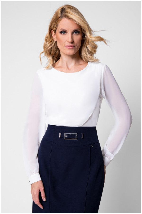 Model in white viscose blouse with sheer sleeves tucked into tweed skirt