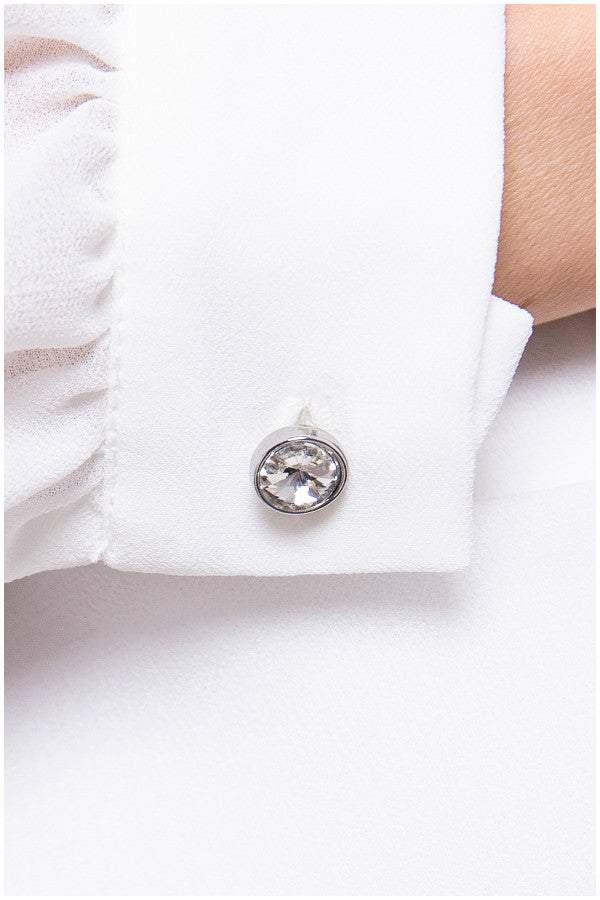 Close up of crystal cuff button on white viscose blouse