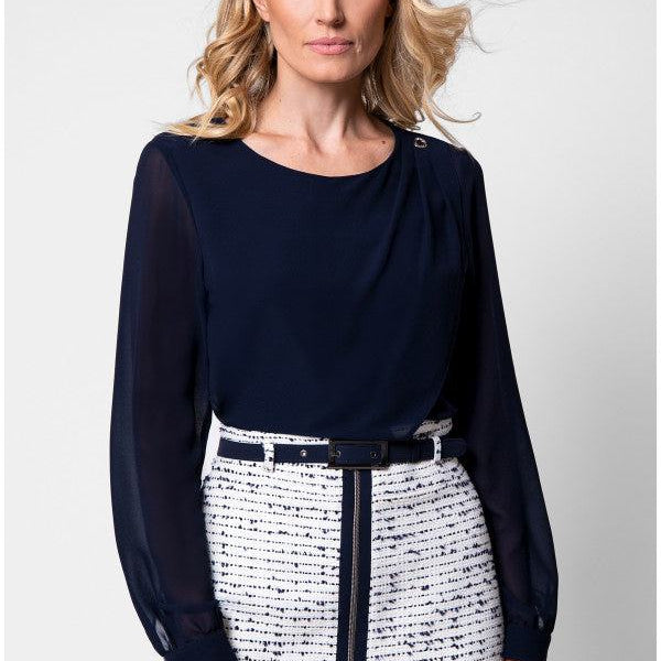 Model in navy viscose blouse with sheer sleeves and tweed skirt front view