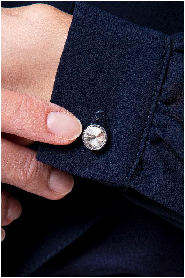 Close up of crystal cuff button on navy viscose blouse