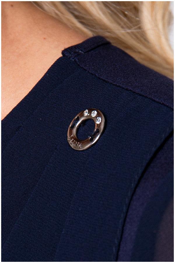 Close up of crystal cuff button on navy viscose blouse