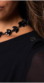 Detail view of model in black viscose blouse with sheer sleeves