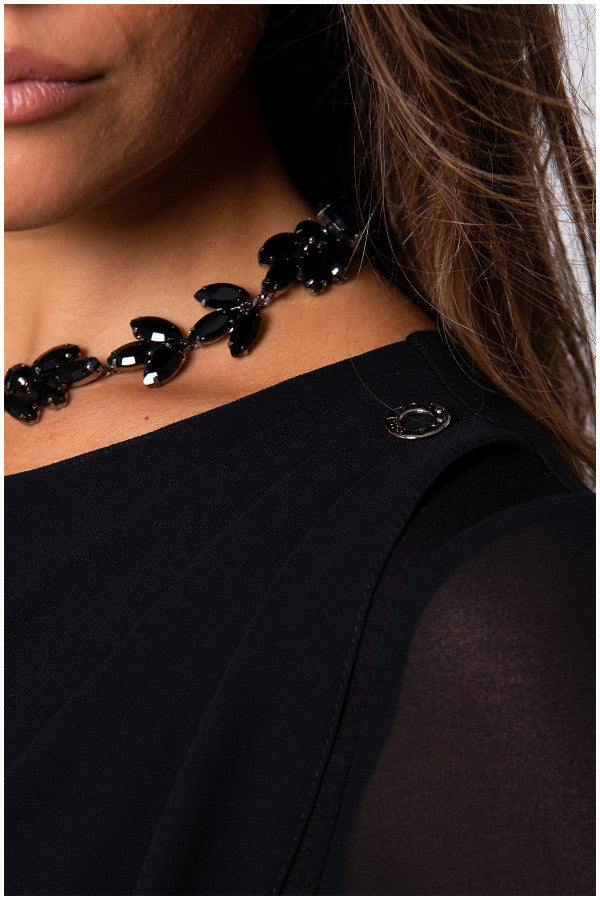 Detail view of model in black viscose blouse with sheer sleeves