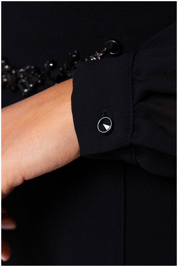 Close up of crystal cuff button on black viscose blouse