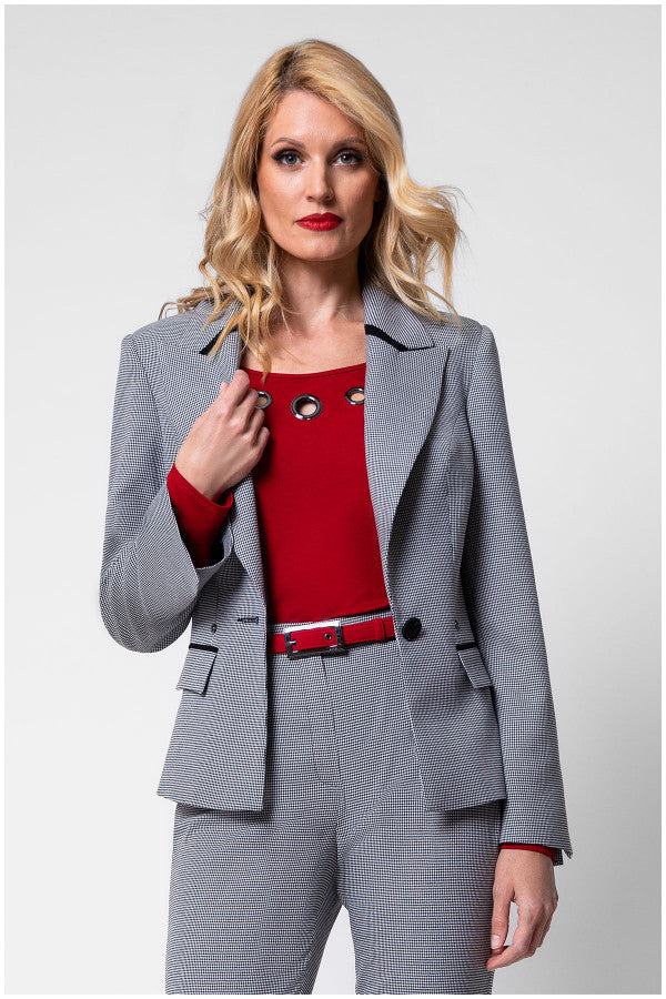 Woman wearing tailored blazer Elena with houndstooth pattern, black collar accents, and matching trousers in a business outfit