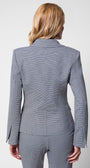 Woman wearing a tailored blazer in houndstooth with structured shoulders and slim fit, viewed from the back.