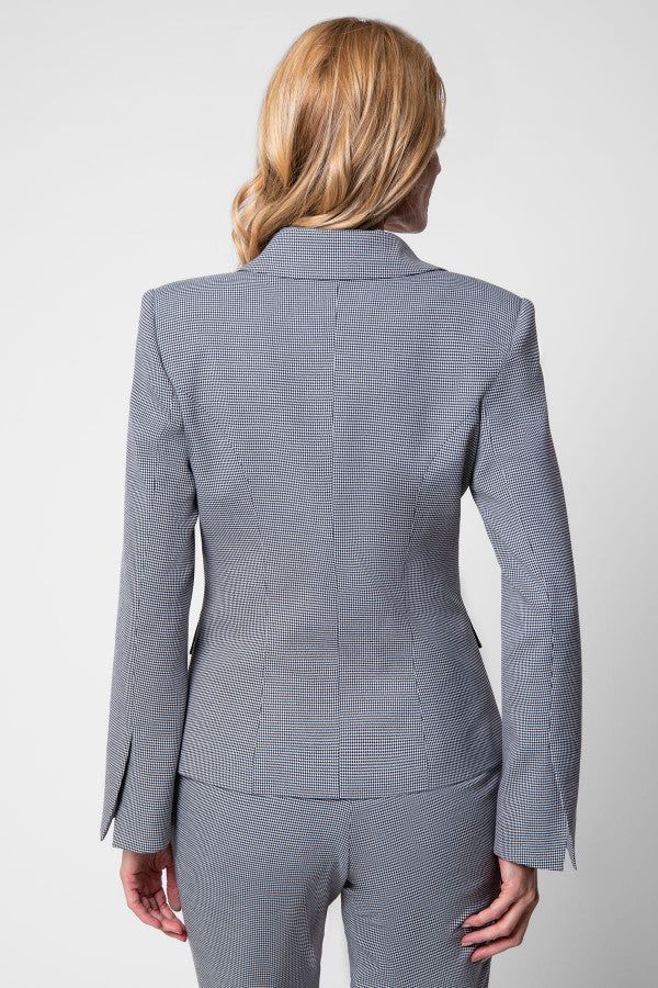 Woman wearing a tailored blazer in houndstooth with structured shoulders and slim fit, viewed from the back.