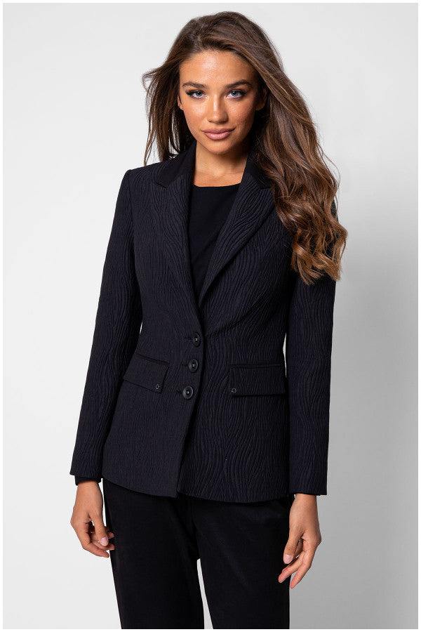Model in black textured blazer and black trousers front view