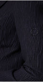 Detail sleeve view of black textured blazer with vent and subtle texture
