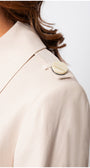 Close-up of the shoulder detail with button on the Kim Classic Long Coat in Beige showcasing refined craftsmanship and elegant design.