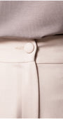 Close-up detail of the button and waistband on the Natasha Wide Leg Trousers in Sand Beige showing smooth fabric texture