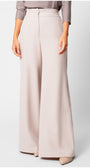 Natasha Wide Leg Trousers in Sand Beige with smooth texture and elegant flowing silhouette on a model