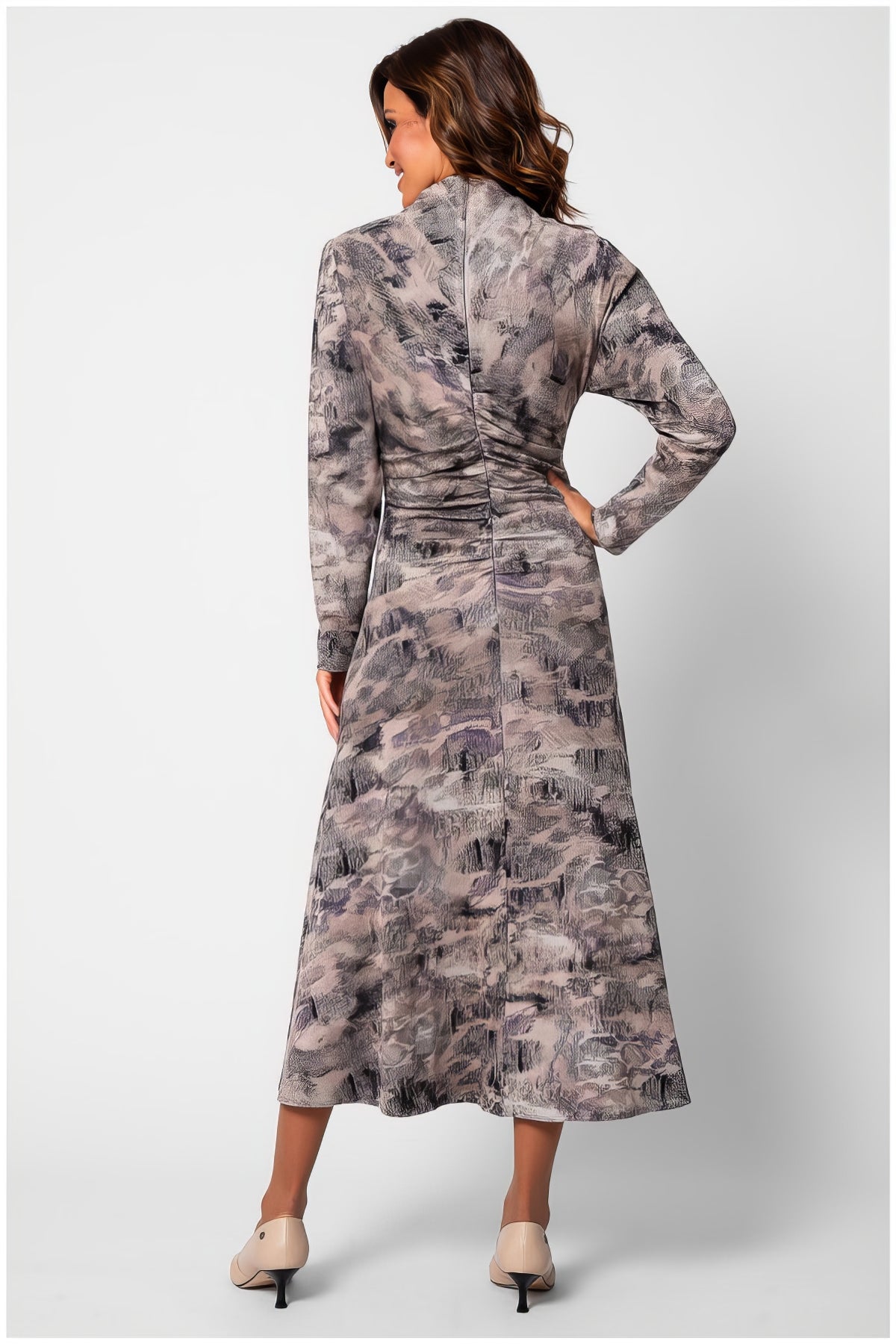 Back view of a woman wearing the Mila Draped Midi Dress in Abstract Taupe with long sleeves and subtle ruching