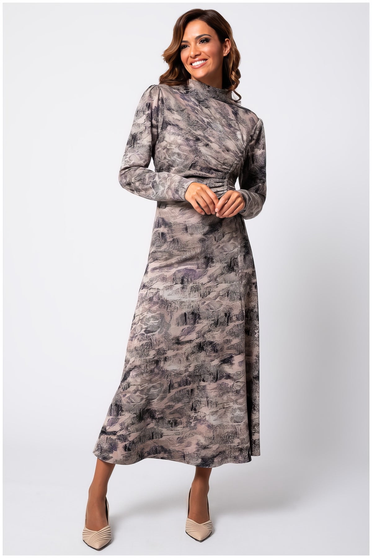 Woman wearing the Mila Draped Midi Dress in Abstract Taupe with long sleeves and a high neckline, smiling confidently.