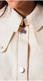 Close-up of textured collar and silver buttons on the Rea Jacquard Trench Coat in Beige showcasing elegant design details