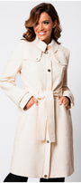Woman wearing Rea Jacquard Trench Coat in Beige with textured fabric and belted waist posing against white background