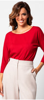 Woman wearing Eva Classic Top in Scarlet Red with three-quarter sleeves paired with light beige trousers against white background