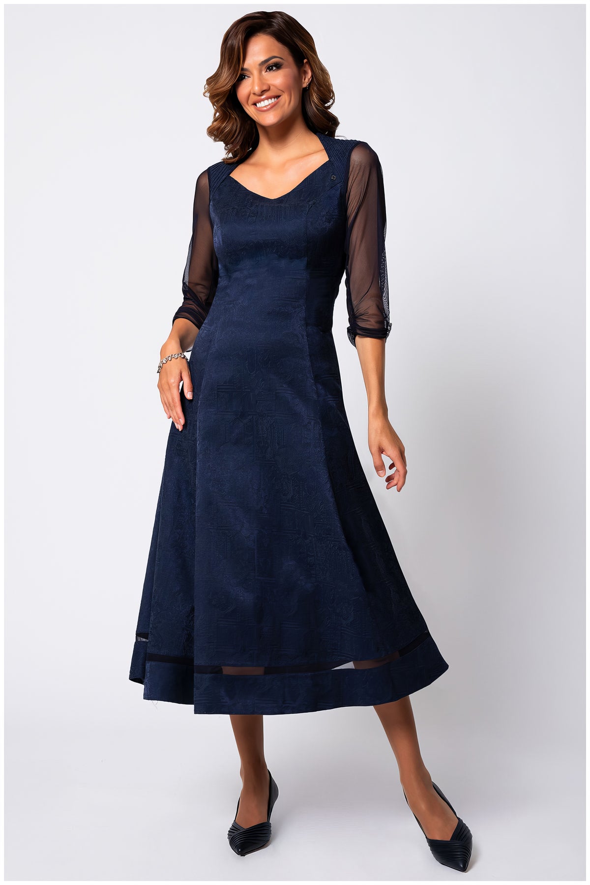 Navy Jacquard Midi Dress, Lucy. Jacquard midi dress. Navy tonal jacquard with a sweetheart V neckline, three quarter sheer sleeves, and a flared skirt with a sheer band near the hem, on model.
