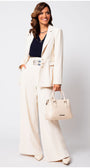 Woman wearing the Agatha Pearl Detail Blazer in Ivory with matching wide-leg pants and a stylish handbag