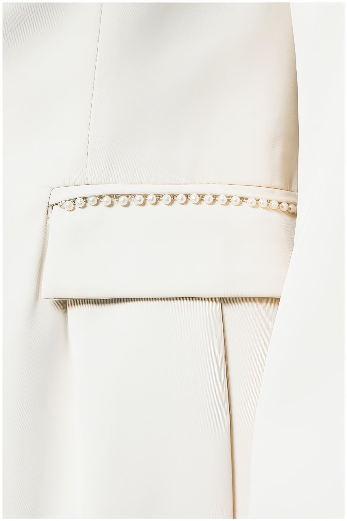 Close-up of pearl embellishment detail on Agatha Pearl Detail Blazer in Ivory pocket trim and tailored fabric