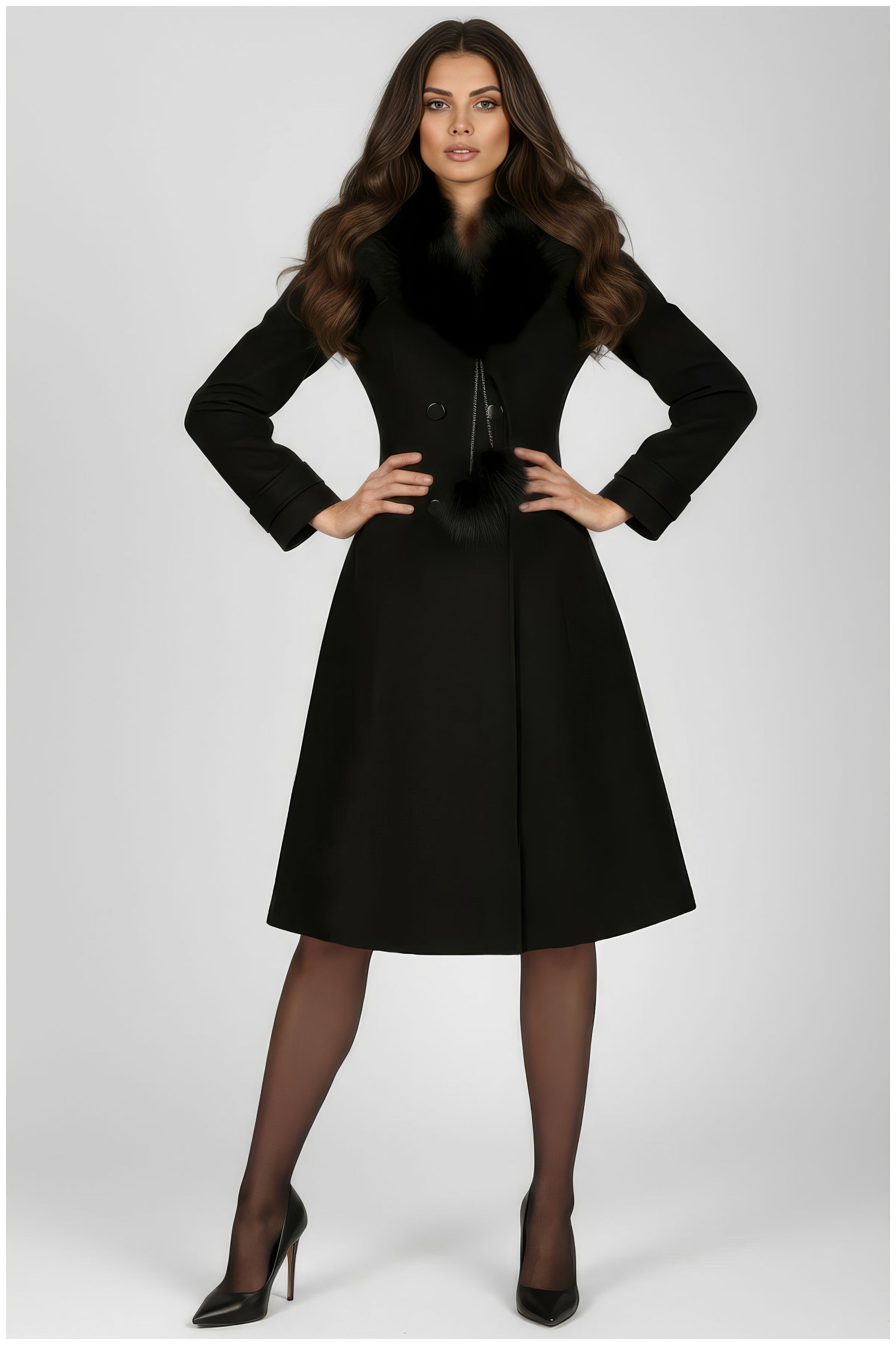 Woman wearing Lucy Wool Coat with Fur Collar in Black with hands on hips and styled hair standing on gray background