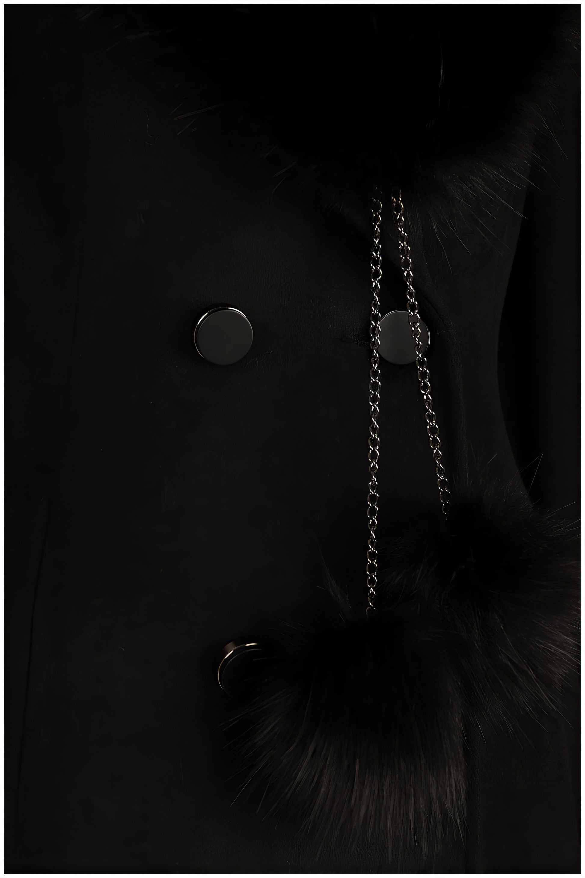 Close-up of Lucy Wool Coat with Fur Collar in Black showcasing buttons and fur pom-pom detail on chain accessory