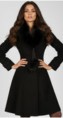 Woman wearing Lucy Wool Coat with Fur Collar in Black with elegant tailored fit and plush fur detailing
