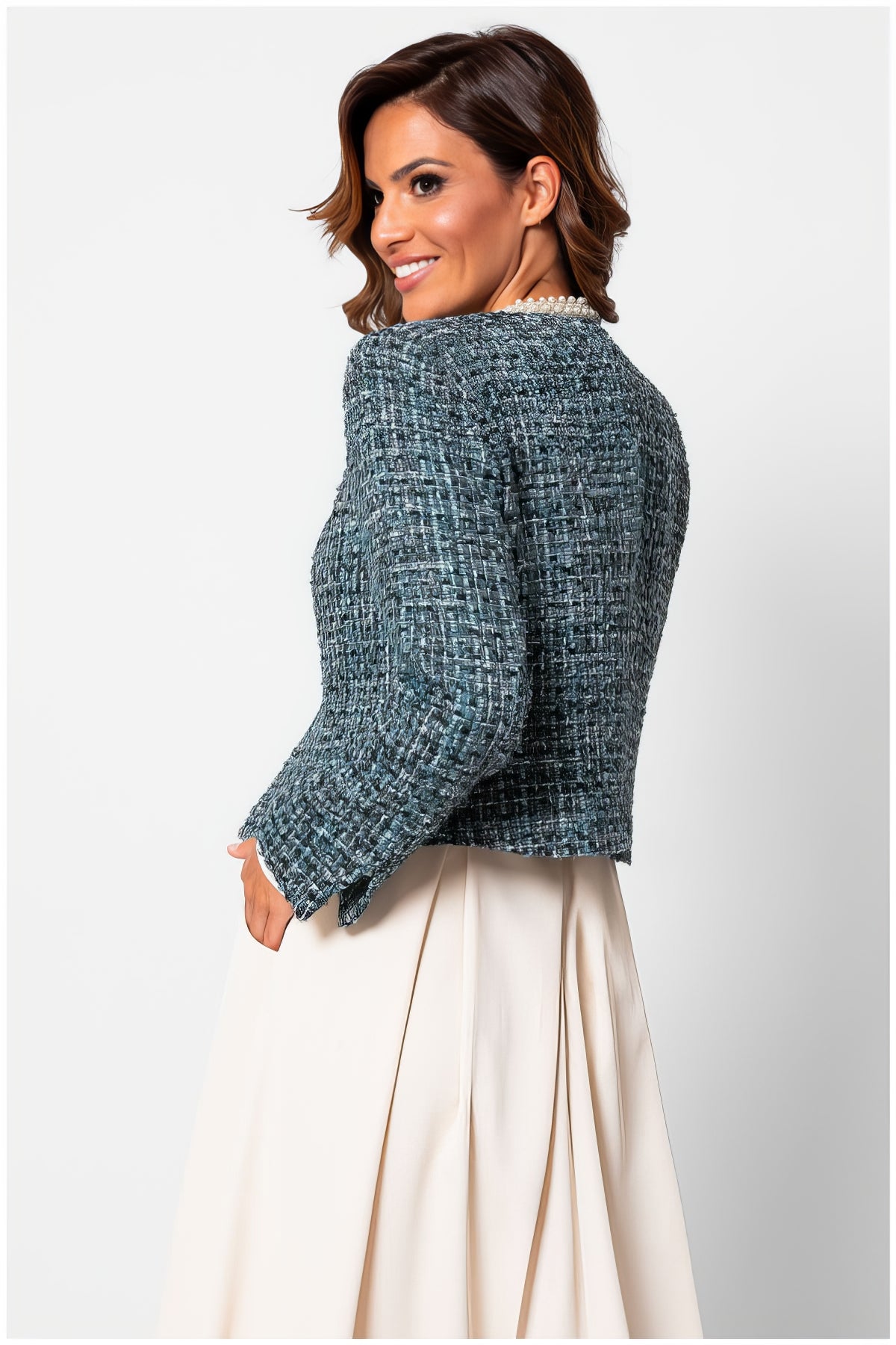 Woman wearing Rhea Tweed Blazer with Pearl Trim in Turquoise Black, paired with a cream skirt against white background