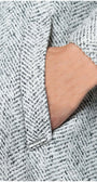 Close-up of hand in pocket showcasing texture of Nicole Wool Wrap Coat in Herringbone Gray fabric detail