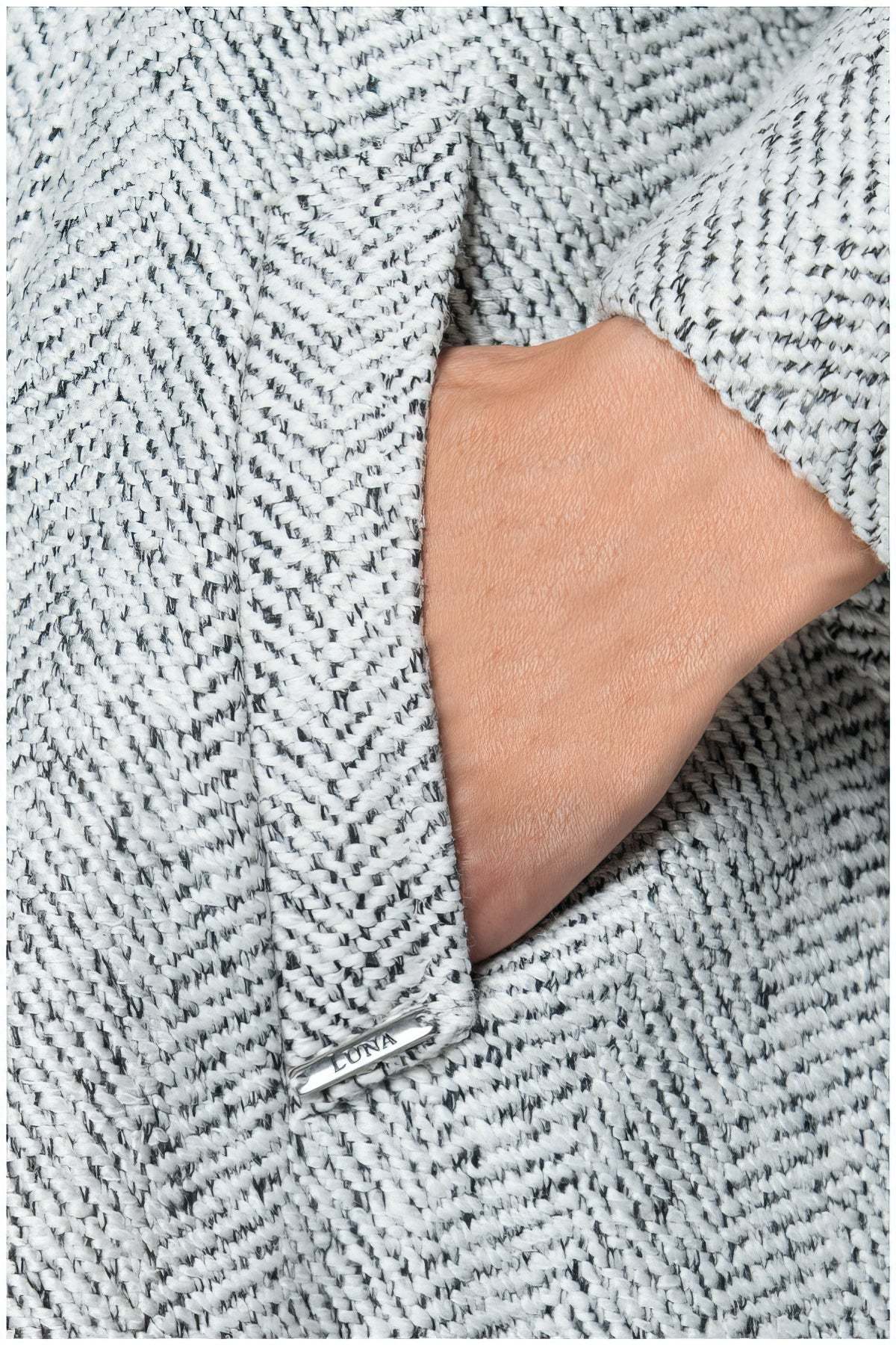 Close-up of hand in pocket showcasing texture of Nicole Wool Wrap Coat in Herringbone Gray fabric detail