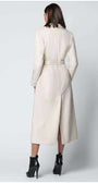 Woman wearing Linea Belted Midi Coat in Ivory with a belted waist and midi length styling from the back view