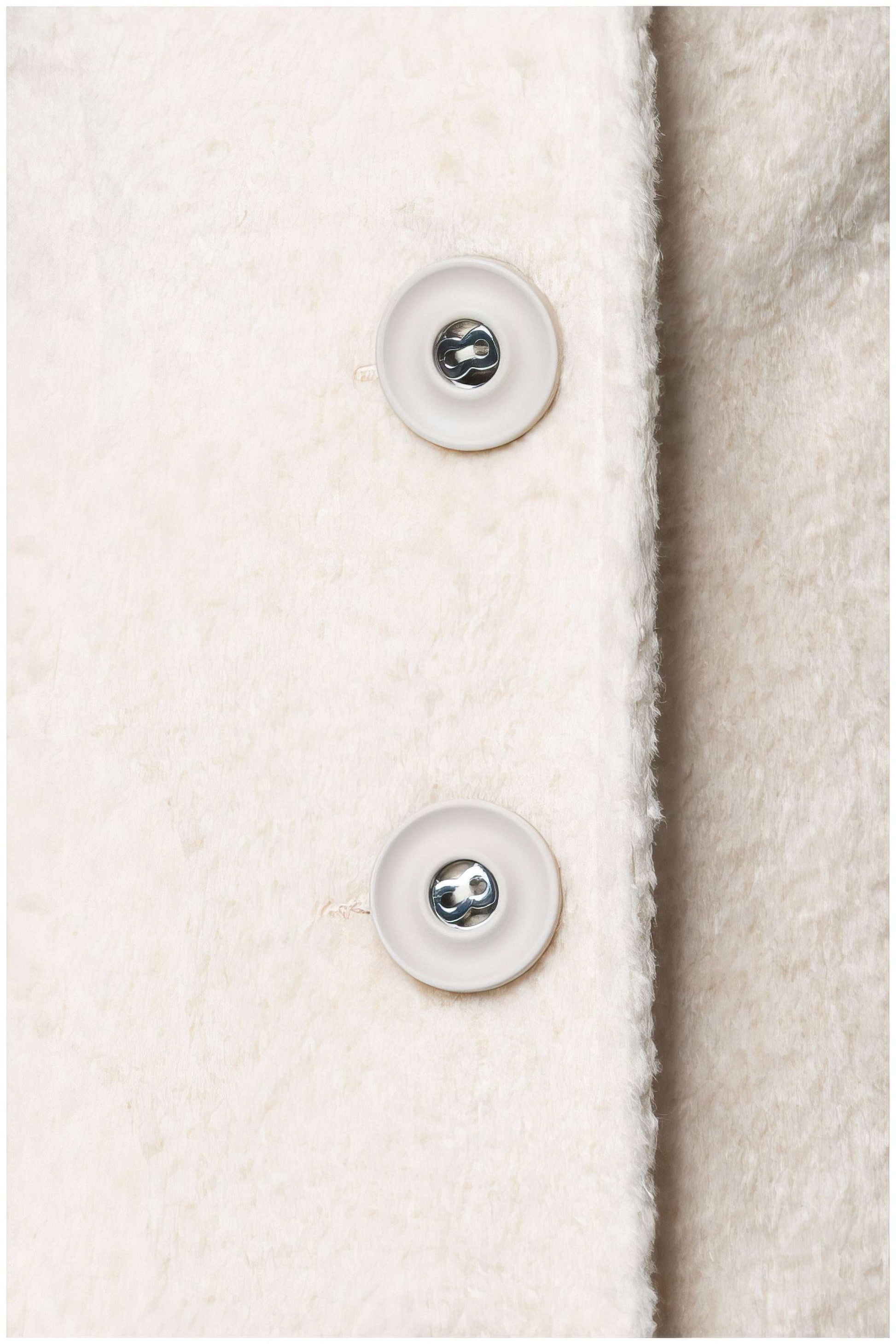 Close-up of button detail on the Linea Belted Midi Coat in Ivory showcasing its soft textured fabric and craftsmanship