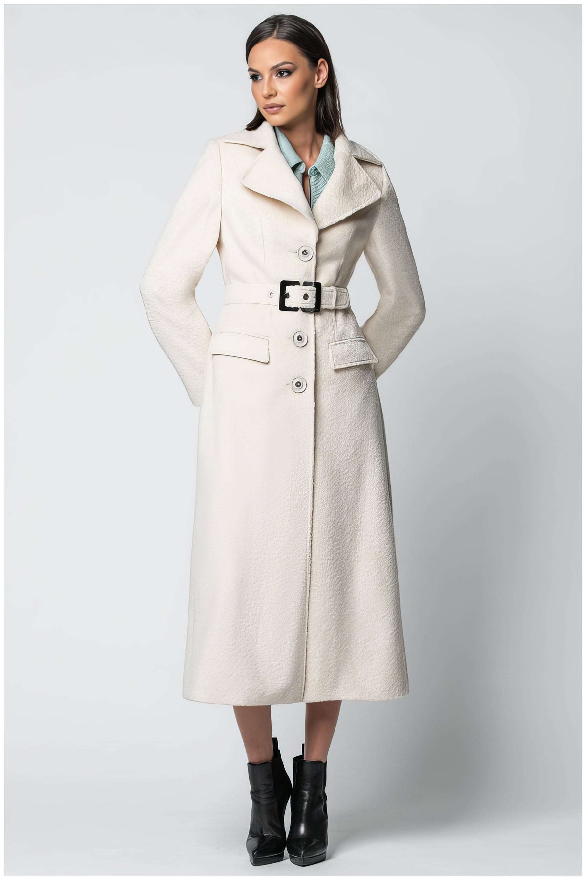 Ivory Belted Midi Coat, Linea. Midi coat. Textured ivory cloth, wide notch lapel, three buttons, and a belt with a black buckle, on model.