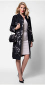 Woman wearing Emma Light Coat with Silver Floral Jacquard over elegant dress posing with black handbag and heels